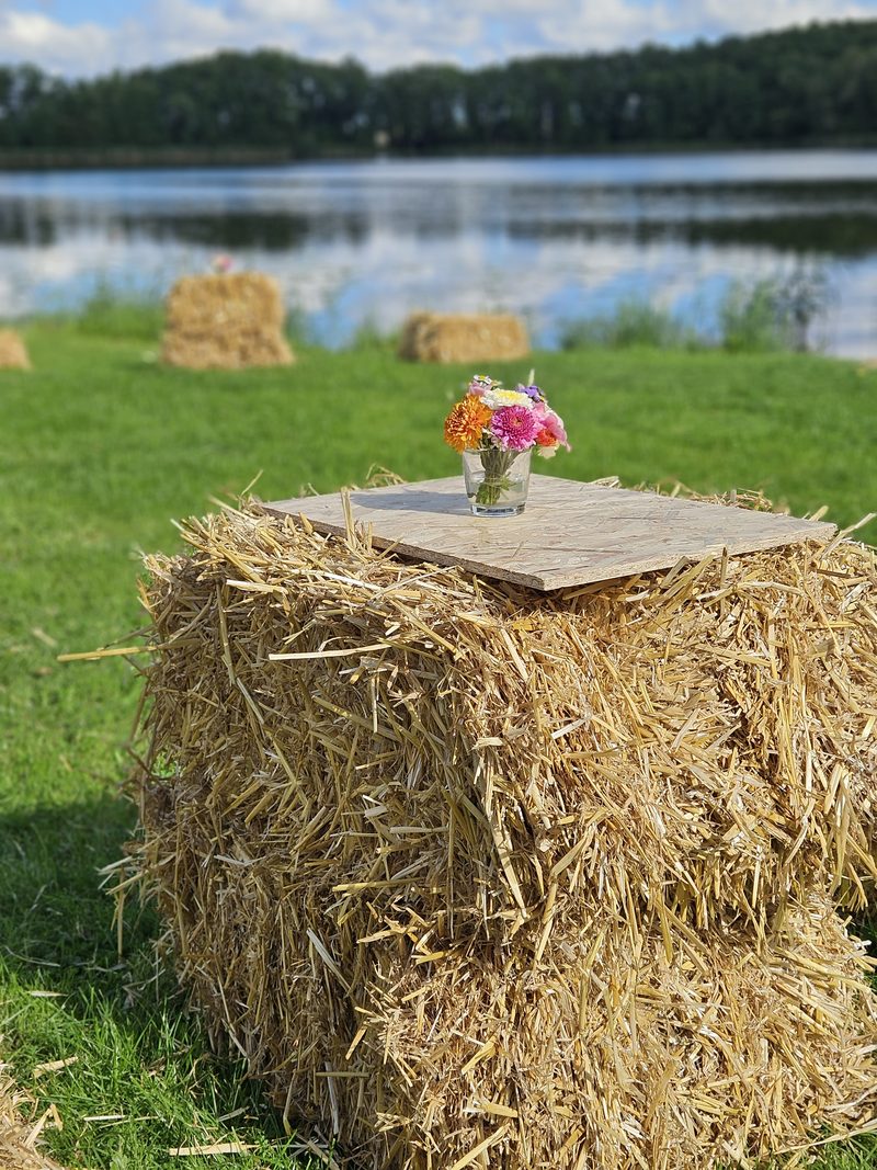 Blumen auf Strohballen am See